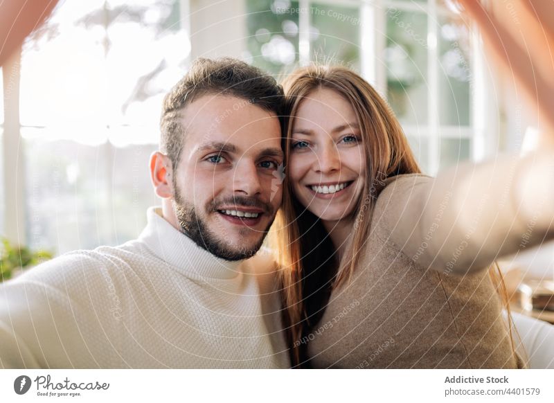 Lächelndes Paar nimmt Selfie im Haus Zimmer heiter Partnerschaft Liebe Moment Gedächtnis romantisch heimwärts Porträt freundlich Selbstportrait herzlich