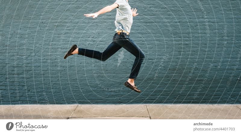 Mann springt gegen eine Wand springen springend Erfolg Fliege Konzept Glück Fröhlichkeit gewinnen anonym unkenntlich Straße Textfreiraum Freude aufgeregt Spaß