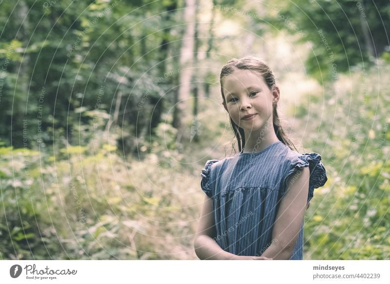 Mädchen im Wald lächelt in die Kamera Natur Kind Kindheit Sommer Spielen Fröhlichkeit Porträt selbstbewusst Lächeln Kinder blaues Kleid Freiheit Erkenntnis
