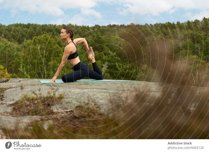 Flexible Frau in Meerjungfrauen-Pose auf einem Felsen Dehnung Yoga Stein Natur Energie Gleichgewicht Meerjungfrau-Pose beweglich Barfuß Asana Körper passen üben