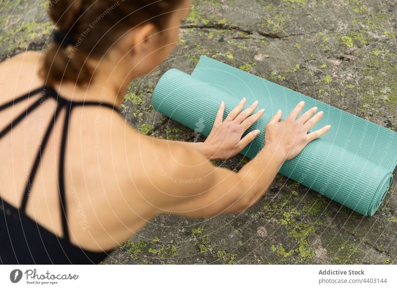 Frau legt Yogamatte auf Stein vorbereiten Unterlage abrollen Natur Start Sitzung üben Gesunder Lebensstil jung Wellness Energie Wohlbefinden Aktivität Felsen