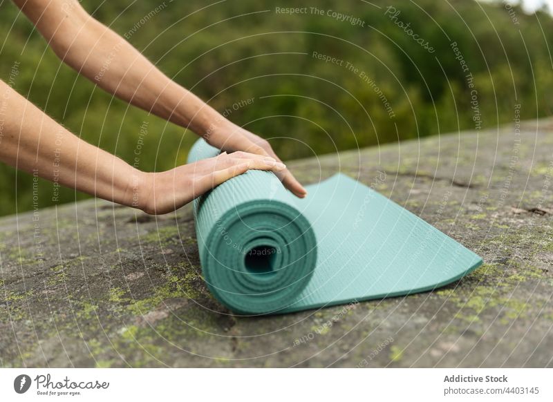 Frau legt Yogamatte auf Stein vorbereiten Unterlage abrollen Natur Start Sitzung üben Gesunder Lebensstil jung Wellness Energie Aktivität Felsen Barfuß