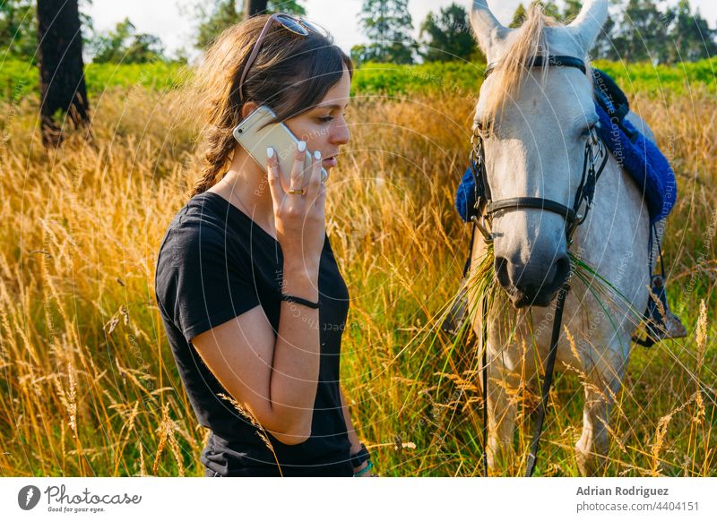 Eine Tierärztin telefoniert mit einem Pferd auf dem Lande Technik & Technologie Zusammensein Beteiligung Frau Telefon Glück Reitsportzentrum Pflege