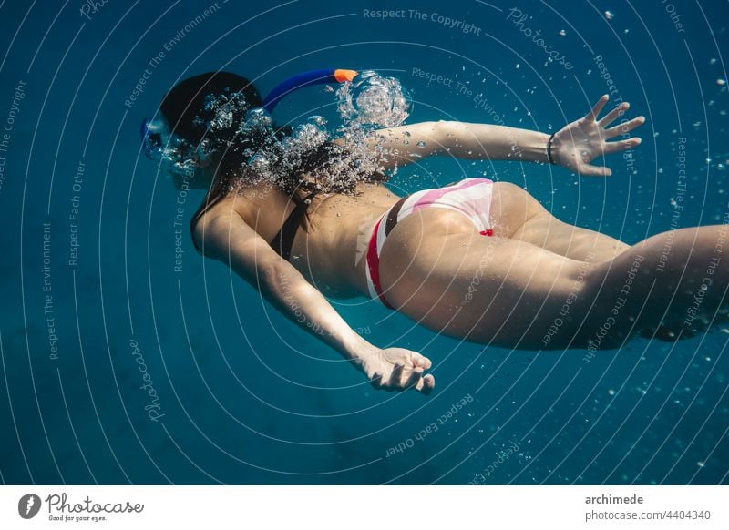 Frau taucht in den Ozean Tauchen Sinkflug Schnorcheln MEER schwimmen Schwimmsport Meer Urlaub Freiheit blau Wasser Lifestyle winken unter Wasser Abenteuer Natur