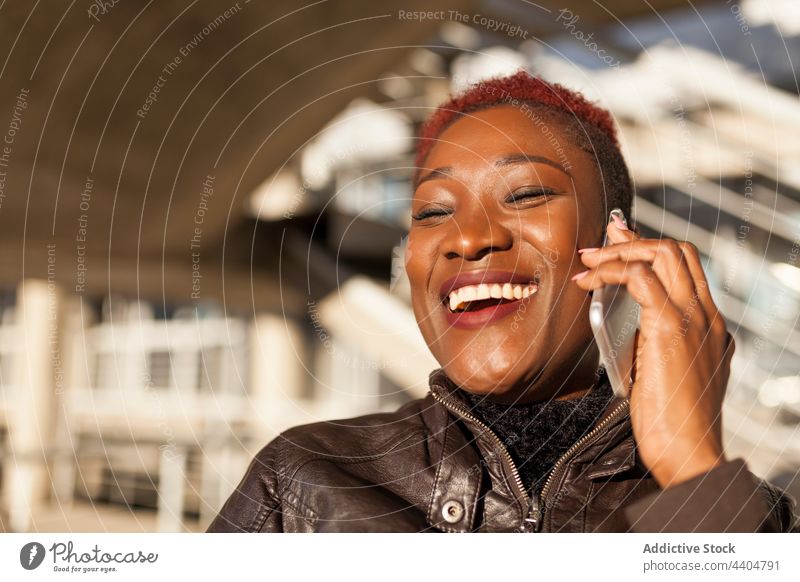 Afro-Frau, die mit ihrem Smartphone spricht schwarz Afro-Look Beteiligung App Mädchen trendy Lifestyle Erwachsener Hintergrund benutzend ethnisch urban Zelle