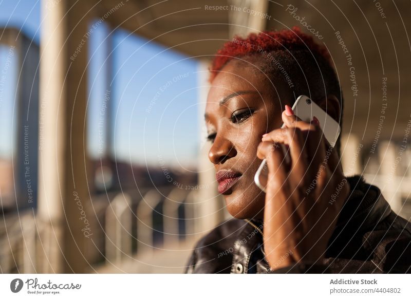 Afro-Frau, die mit ihrem Smartphone spricht schwarz Afro-Look ernst Beteiligung App Mädchen trendy Lifestyle Erwachsener Hintergrund benutzend ethnisch urban