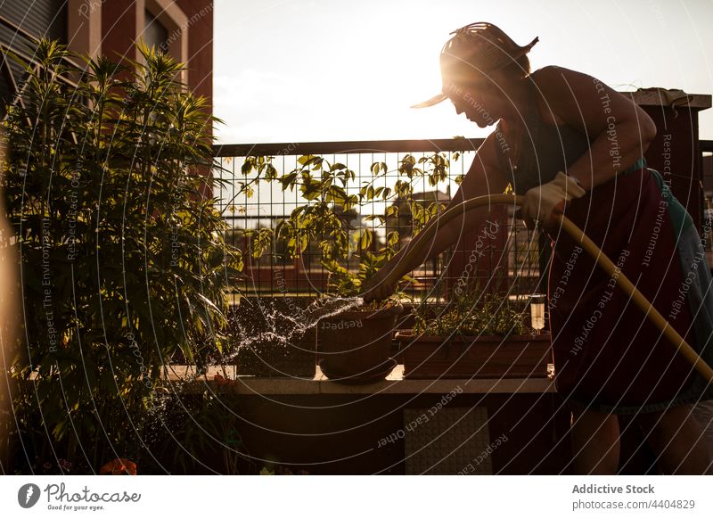 Gärtnerin bewässert ihren Garten mit einem Schlauch Frau Wasser Botanik Natur Arbeit Frühling wachsend Kaukasier schön Hobby im Freien Blütezeit jung botanisch