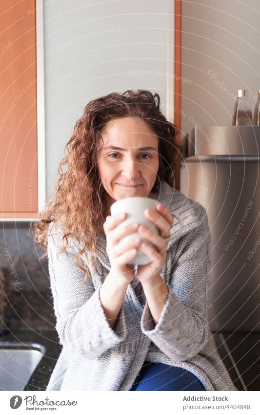 Frau in der Küche bei der Einnahme eines Aufgusses Gesundheit schön trinken Innenbereich Sitzen heimwärts im Innenbereich Morgen Frühstück Schalen & Schüsseln