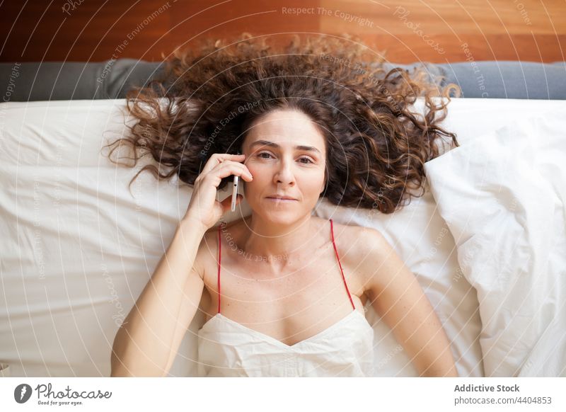 Geschäftsfrau, die zu Hause arbeitet Frau Smartphone Bett genießend im Innenbereich Anschluss sich[Akk] unterhaltend Erwachsener Antwort an Ansicht Mobile