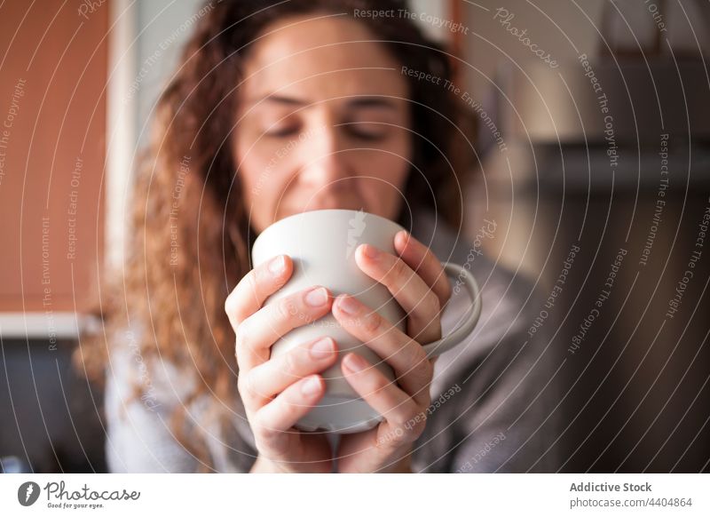 Frau in der Küche bei der Einnahme eines Aufgusses Gesundheit schön trinken Innenbereich Sitzen heimwärts im Innenbereich Morgen Frühstück Schalen & Schüsseln