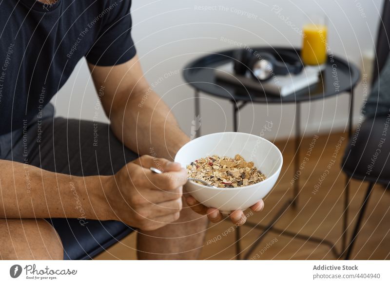 Crop Man isst Müsli zum Frühstück Mann Morgen Schalen & Schüsseln essen Lebensmittel Gesundheit heimwärts männlich Mahlzeit Ernährung frisch Bestandteil