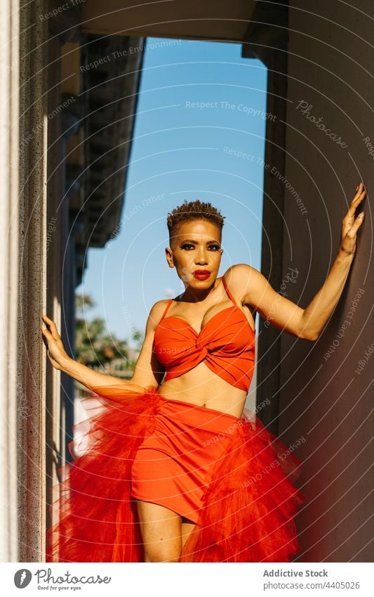Stilvolle schwarze Frau mit Make-up und modernem Haarschnitt auf der Straße Mode selbstbewusst Individualität cool Porträt rot Stoff dekorativ Kosmetik Spalte