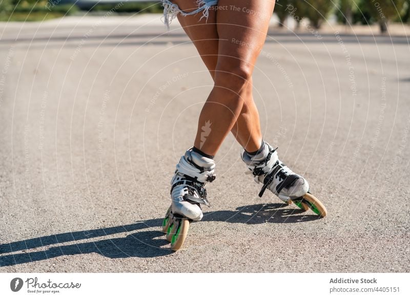 anonyme Frau in Rollschuhen und mit Stunt Rollerblade Trick Ausgeglichenheit Skater Sommer Rad Straße Aktivität üben sonnig Sonnenlicht Sommerzeit Beine