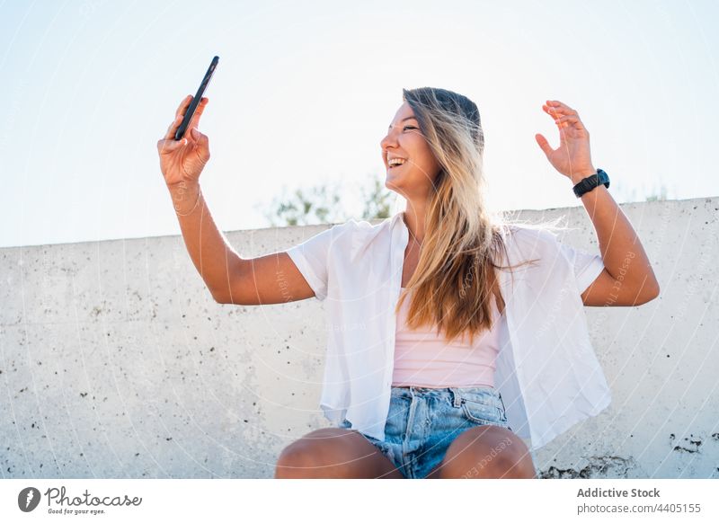 Lächelnde Frau nimmt Selfie auf der Straße Smartphone Großstadt Sommer Selbstportrait Moment Glück heiter Gedächtnis Mobile Gerät Funktelefon fotografieren