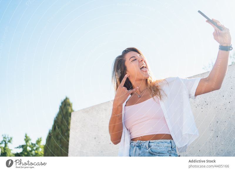 Lächelnde Frau nimmt Selfie auf der Straße Smartphone Großstadt Sommer Selbstportrait Moment Glück heiter Gedächtnis Mobile Gerät ausspannen klebend