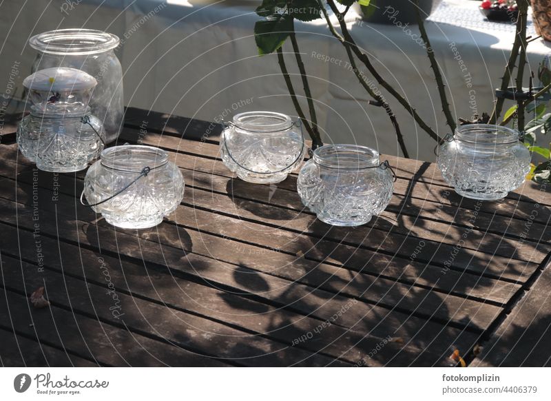 Kerzenlicht-Gläser auf einem Gartentisch Tischdekoration Kerzenglas Teelicht Gartenfest Teelichtständer Teelichter gläsern Holztisch festlich