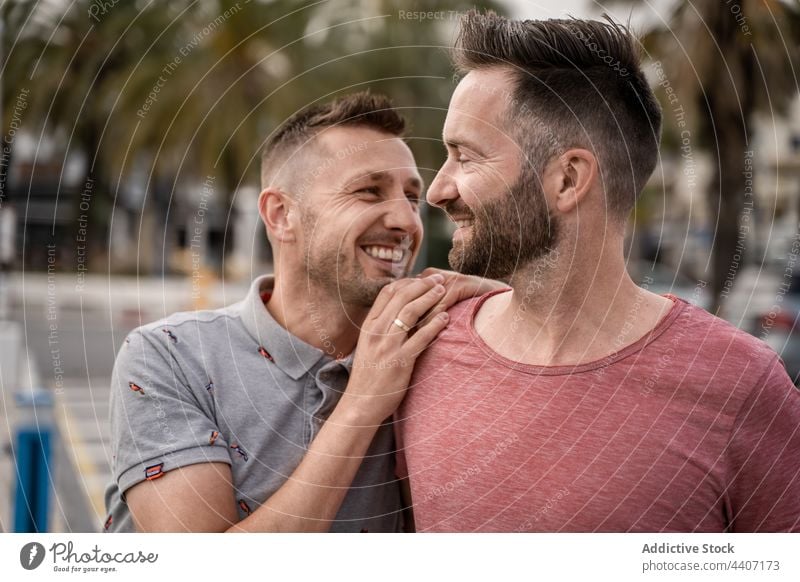 Fröhliche Schwule, die sich umarmen, während sie im Hafen wegschauen Paar gleichgeschlechtlich Umarmen Liebe sprechen Partnerschaft Zeit verbringen herzlich