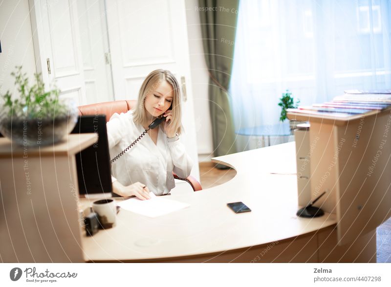 Junge weibliche Empfangsdame spricht am Telefon im Büro Sekretärin Rezeption Mädchen Frau Business Arbeit Unternehmen professionell Personal Schreibtisch formal