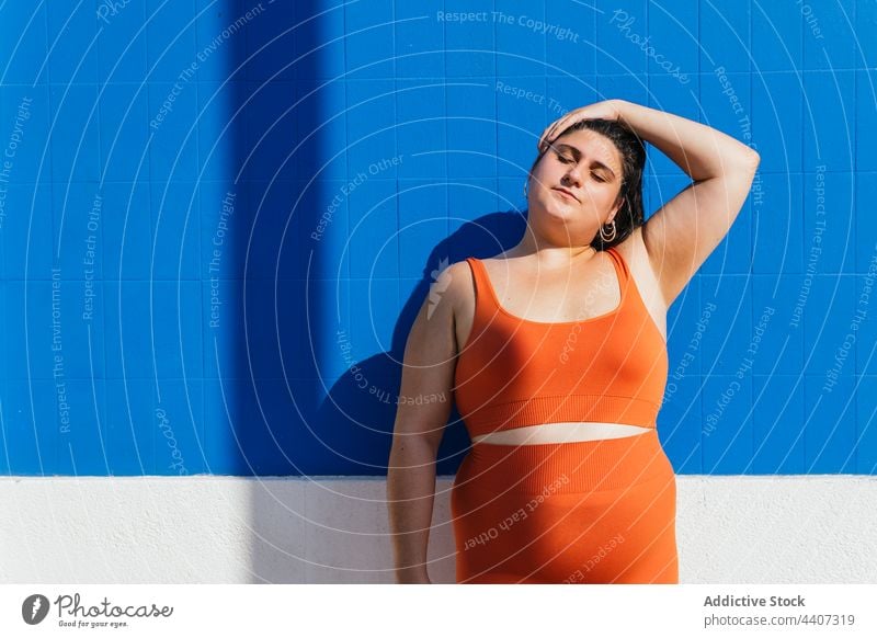 Übergewichtige ethnische Sportlerin streckt ihren Nacken beim Training auf der Straße Dehnung Tastkopf Aufwärmen Übung Übergröße Frau Athlet mollig