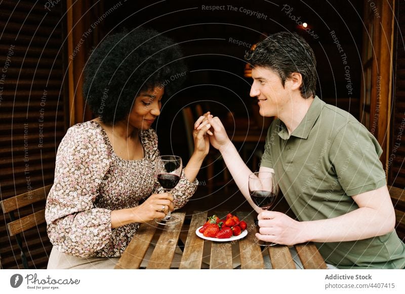 Inhalt multiethnisches Paar mit Gläsern bei romantischem Date Glas Rotwein Termin & Datum jubelt Händchenhalten Liebe rassenübergreifend vielfältig schwarz