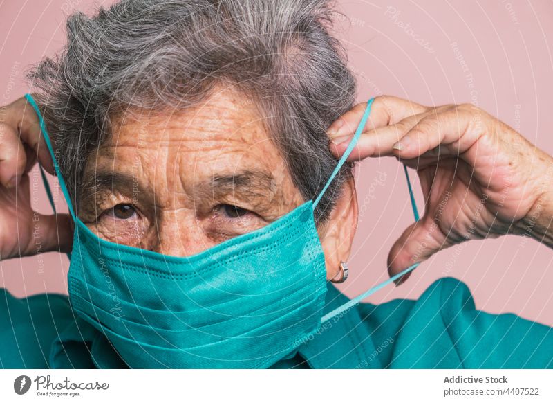 Ältere Frau mit medizinischer Maske im Studio gealtert Mundschutz neue Normale behüten Coronavirus älter verhindern Bund 19 Senior Lächeln Deckel Mund