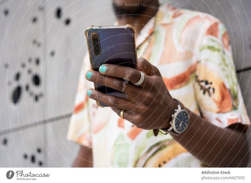 Anonym ermittelter schwarzer Mann Textnachricht auf Smartphone in der Stadt selbstbewusst Funktelefon Großstadt Browsen Bestimmen Sie Stil männlich
