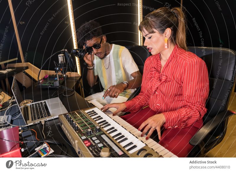 Verschiedene Musiker arbeiten gemeinsam im Tonstudio Aufzeichnen Atelier spielen elektrisch Klavier zuhören Kopfhörer Zusammensein rassenübergreifend