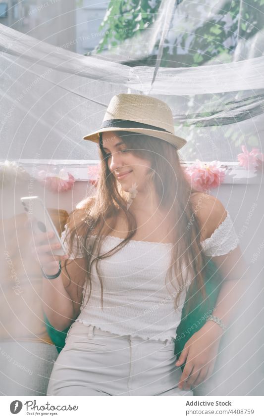 Lächelnde Frau, die im Zelt im Hinterhof auf ihrem Smartphone surft Browsen Nachricht soziale Netzwerke benutzend Mobile Telefon Inhalt Apparatur Gerät