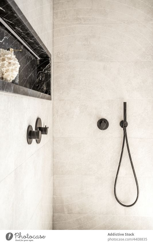 Duschkabine im modernen Badezimmer mit gefliesten Wänden Dusche Innenbereich Kabine sehr wenige Stil schwarz Wasserhahn Handgriff Schlauch Design Sauberkeit