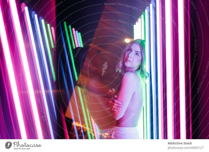 Sinnliches Oben-ohne-Modell in leuchtenden Neonröhren sinnlich oben ohne neonfarbig verträumt feminin natürlich Schönheit Frau Porträt sensibel herzlich