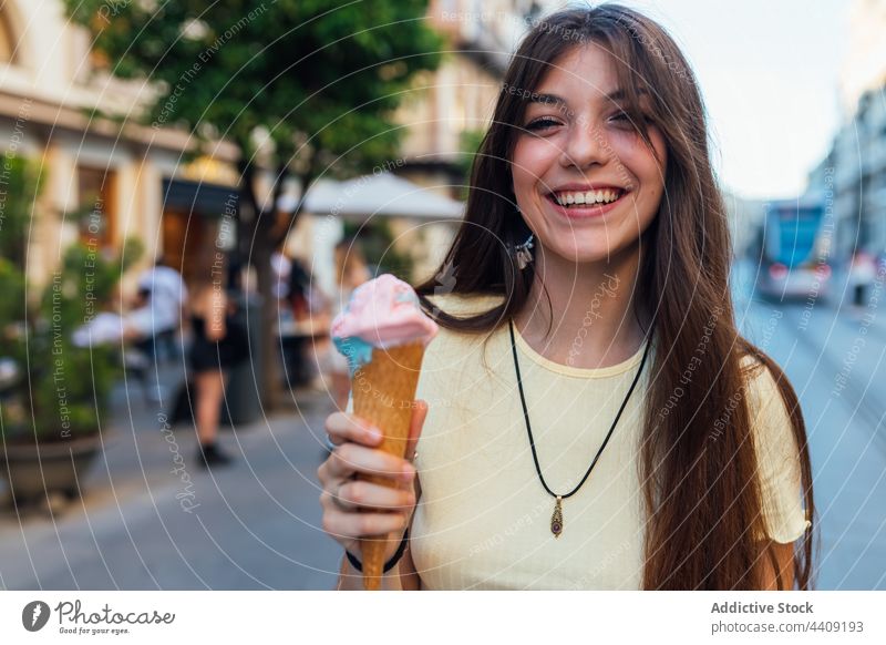 Glückliche Frau mit leckerer Eistüte in der Stadt Speiseeis Zapfen Lächeln Dessert Leckerbissen süß geschmackvoll Porträt Waffel Straße knackig gelato Geschmack