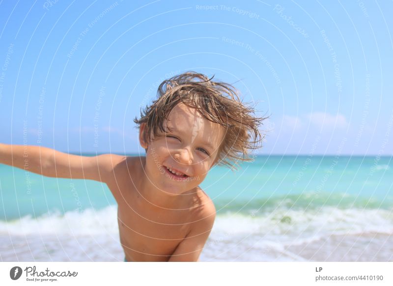 Gesicht eines schönen Kindes, das am Meer in die Kamera lächelt positive Emotion Lächeln Strand einzeln vereinzelt Single abstrakt Bewegung fließen Kinderspiel