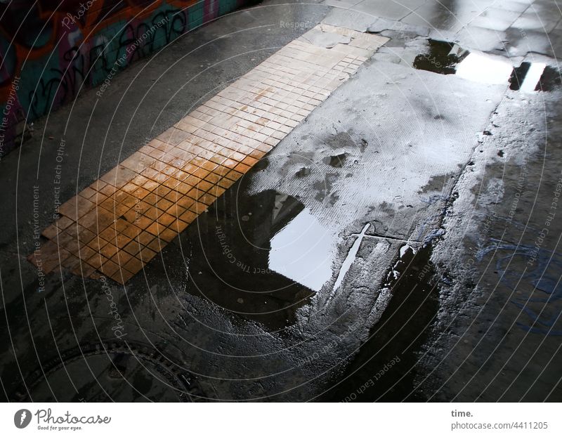!Trash! | Wasserstand asphalt pfütze fußweg spiegelung wasser nass stein fliesen kacheln delle kaputt schwarz gelb urban bebauung architektur torweg abdruck