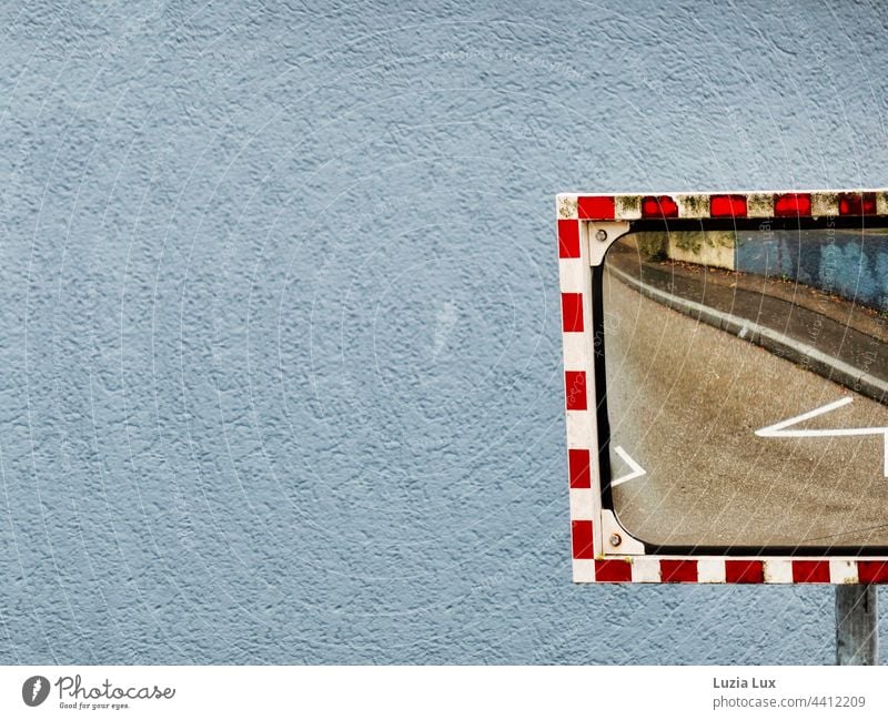 Zickezacke: Fahrbahnmarkierungen und Gehweg spiegeln sich in einem Straßenspiegel mit schmutzigem Rand Wand Putz Putzfassade zickzack Mauer Fassade Farbfoto