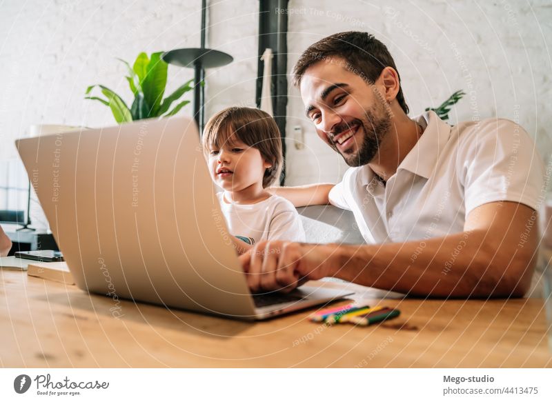 Ein Vater hilft seinem Sohn bei der Online-Schule zu Hause. monoparentiell Laptop online Hausaufgabe Schüler Lernen Lifestyle Quarantäne Familie Kinder Menschen