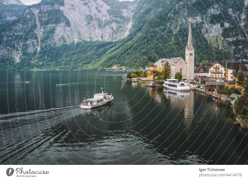 Bergsee und Ausflugsboot, das das Dorf Hallstatt erreicht, mit den Alpen im Hintergrund. Österreich See Ansicht berühmt Stadt Landschaft Natur Tourismus