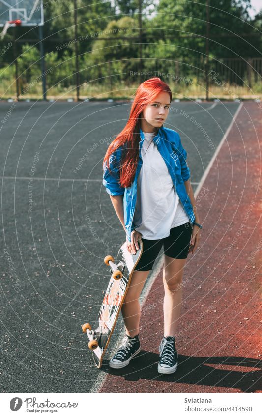 Porträt eines charmanten Mädchens mit einem Skateboard in der Hand auf einem Sportplatz Sportpark Straße Teenager Hobby Schlittschuh Lifestyle jung Frau hübsch