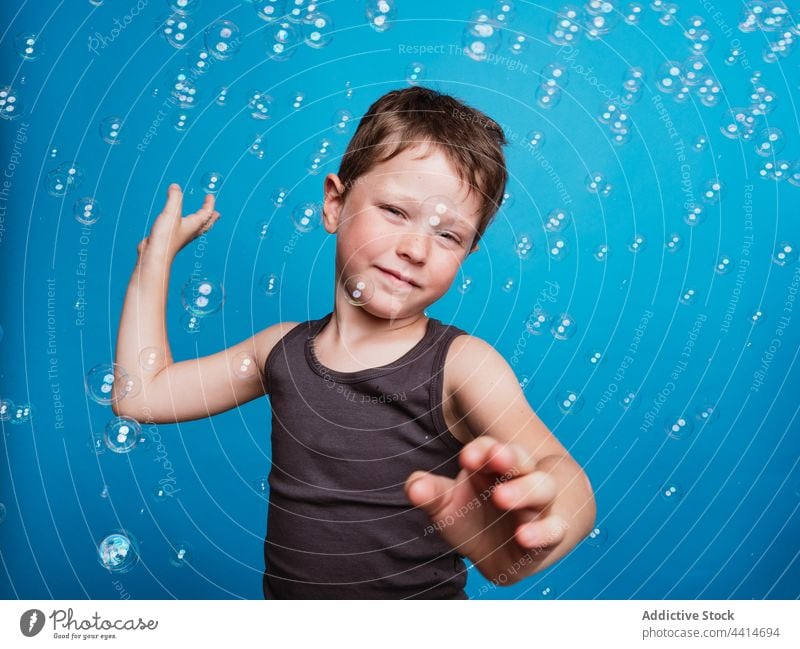 Kind schaut im Studio mit Seifenblasen in die Kamera Junge Überraschung Kindheit Gesichtsausdruck wow Reaktionen u. Effekte Zeichen Symbol zeigen virtuell