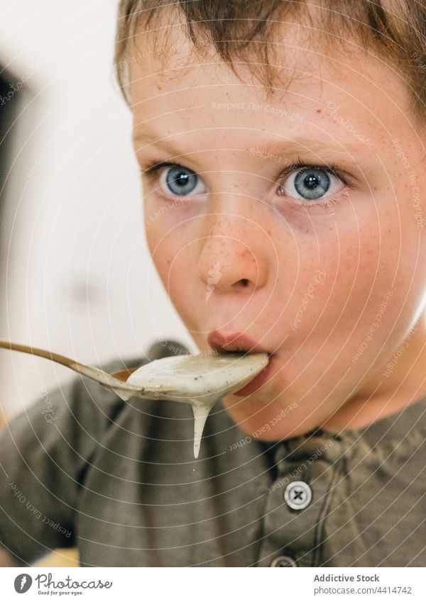 Kind mit Löffel isst Cremesuppe essen lutschen Mittagessen Sahne Suppe Junge Mahlzeit Lebensmittel heimwärts Speise geschmackvoll Küche niedlich lecker