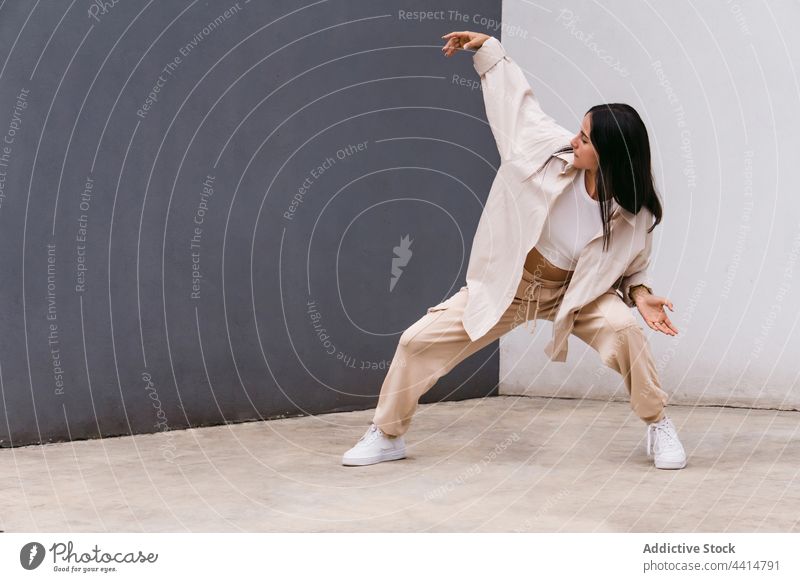 Stilvolle Frau tanzt auf der Straße in der Nähe der Mauer Tänzer Talent sich[Akk] bewegen Tanzen Großstadt Choreographie urban Wand beweglich Anmut Fähigkeit