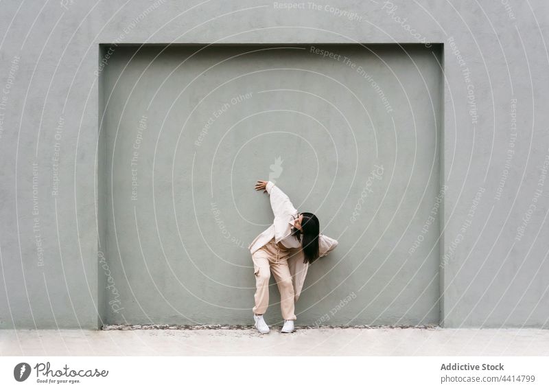 Talentierte Frau tanzt gegen graue Wand in der Stadt Tanzen Tänzer Großstadt Straße Energie Stil urban cool beweglich sich[Akk] bewegen Choreographie fettarm