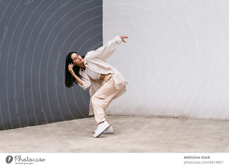 Flexible Frau tanzt in der Nähe von grauen und weißen Wand in der Stadt Tanzen Tänzer Großstadt ausführen Straße beweglich Choreographie sich[Akk] bewegen Anmut