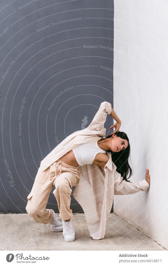 Flexible Frau tanzt in der Nähe einer Mauer in der Stadt Tanzen Tänzer Großstadt ausführen Wand Straße beweglich Choreographie sich[Akk] bewegen Anmut Talent