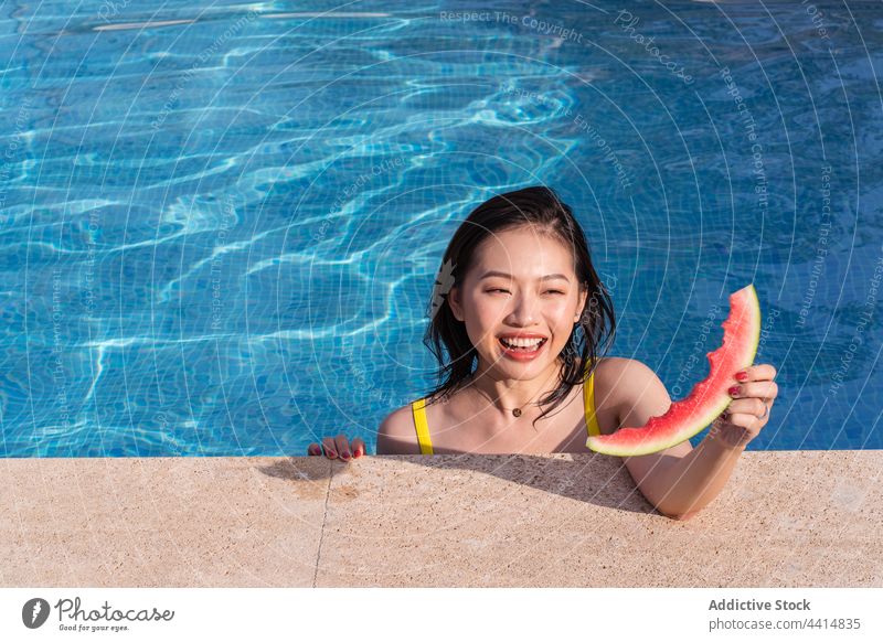 Inhalt Asiatische Frau im Schwimmbad mit Wassermelone Pool Sommer genießen Glück Resort Urlaub ethnisch asiatisch frisch Sommerzeit Wochenende heiter Scheibe