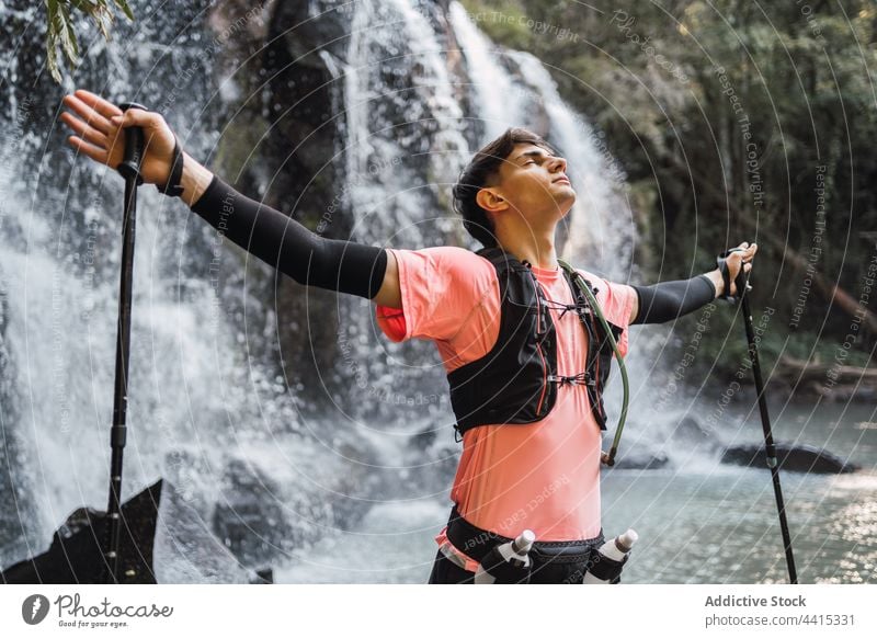 Unbekümmertes Reisen, die Freiheit in der Nähe eines Wasserfalls im Wald genießen Mann Reisender sorgenfrei verträumt Trekking Abenteuer männlich Natur Erholung