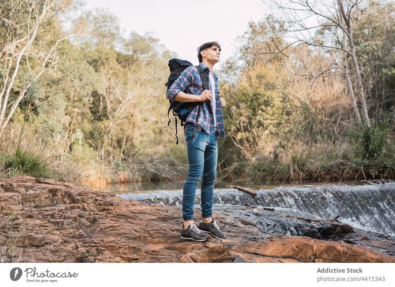 Reisender Mann steht in der Nähe eines kleinen Wasserfalls im Wald Rucksack Wanderer Trekking Wälder reisen Abenteuer männlich Natur erkunden Backpacker Umwelt