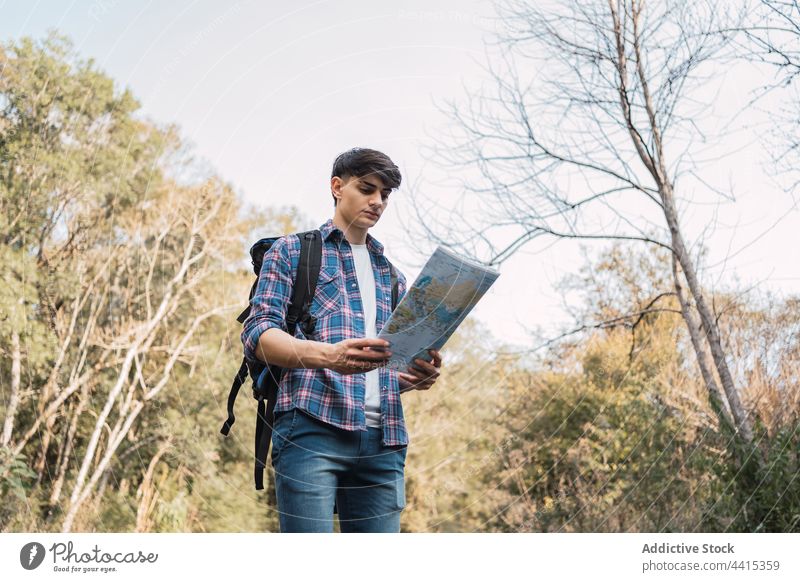 Reisender Mann, der sich im Wald auf einer Karte orientiert Wanderer Landkarte sich orientieren navigieren finden Trekking Wanderung reisen männlich erkunden