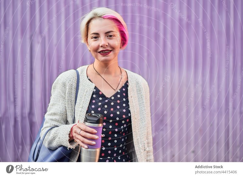 Stilvolle alternative Frau mit Kaffee im wiederverwendbaren Becher informell wiederverwenden Tasse umweltfreundlich Lächeln trinken Großstadt cool Straße
