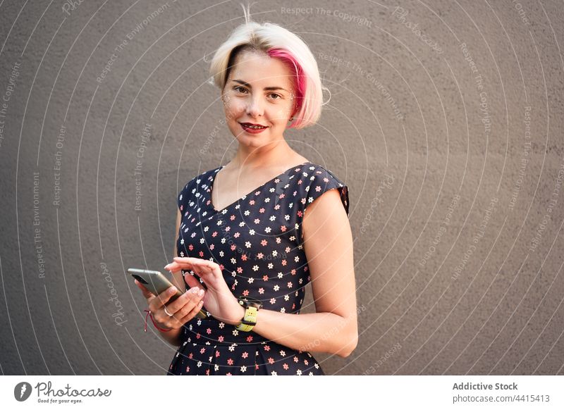 Inhalt Alternative Frau mit Smartphone in der Stadt benutzend Nachricht alternativ informell Stil heiter Großstadt Browsen Subkultur ausgefallen Kleid