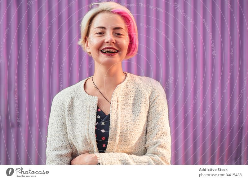 Informelle Frau mit gefärbtem Haar auf lila Hintergrund in der Stadt informell gefärbtes Haar Lächeln Vorschein Stil urban Großstadt trendy Subkultur Outfit
